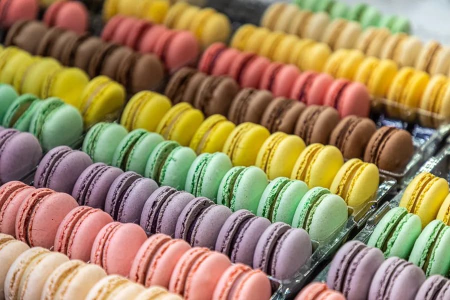 Rows of freshly made By Eric macarons in every flavour, filling the counter in Puerto Banús